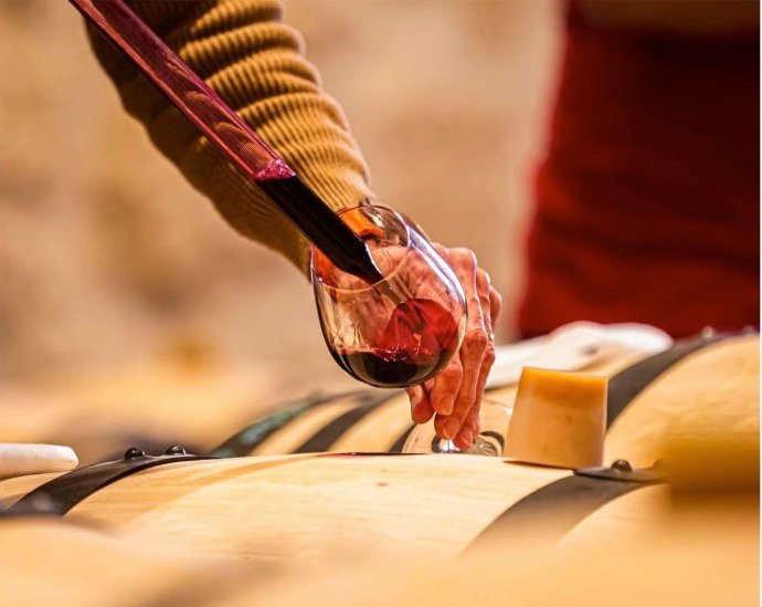 Dégustation à la pipette directement à la barrique lors d’un atelier œnologique à offrir dans le vignoble de Bordeaux