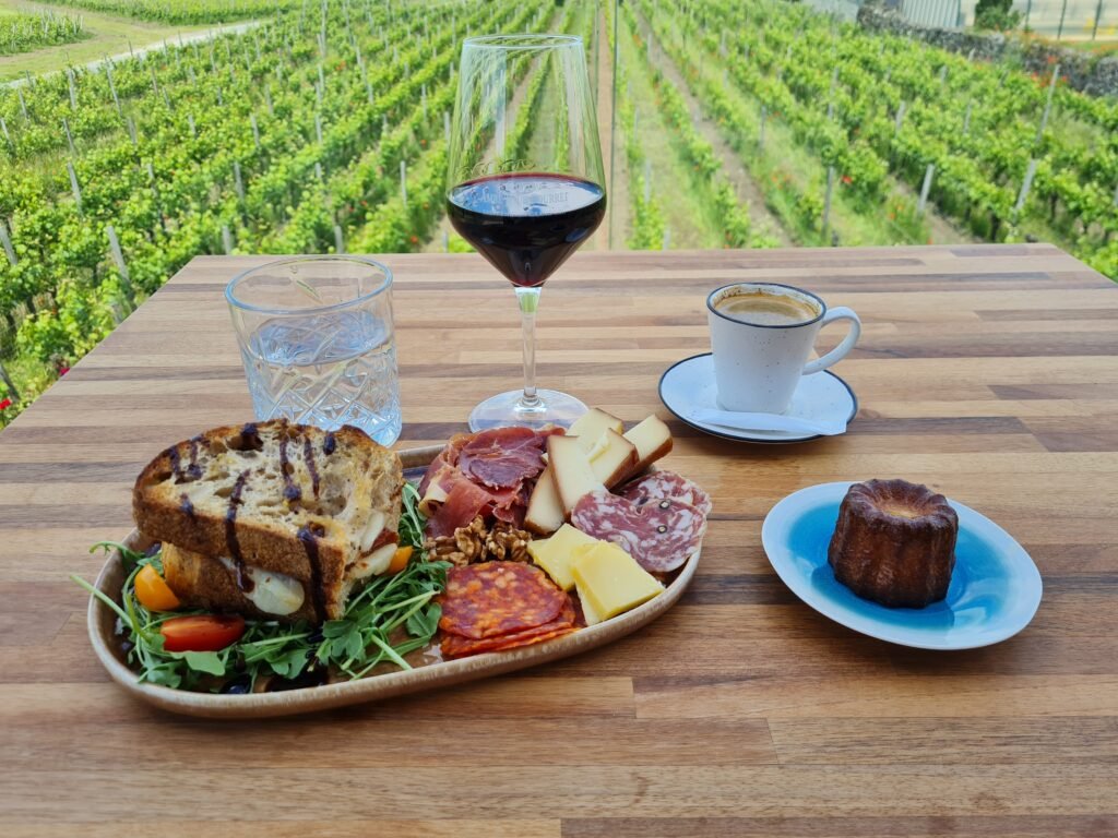 Planche gourmande, verre de vin rouge et café servis face aux vignes lors d’une pause gourmande à Saint-Émilion