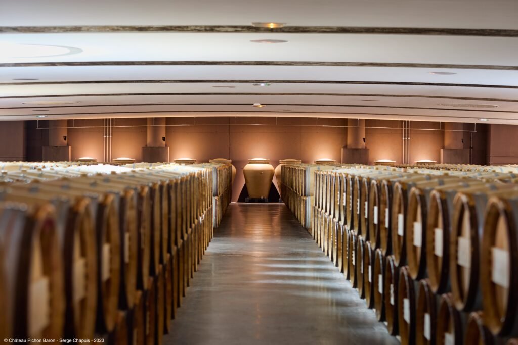 Chai de Saint-Émilion aux rangées de barriques alignées, offrant un cadre authentique pour une visite œnologique haut de gamme à Bordeaux.