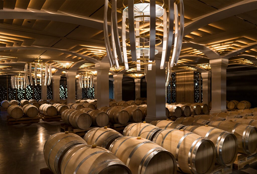 Chai lumineux aux barriques alignées dans un Grand Cru Classé, cadre d’exception pour une visite de cave et un weekend œnologique à Bordeaux.