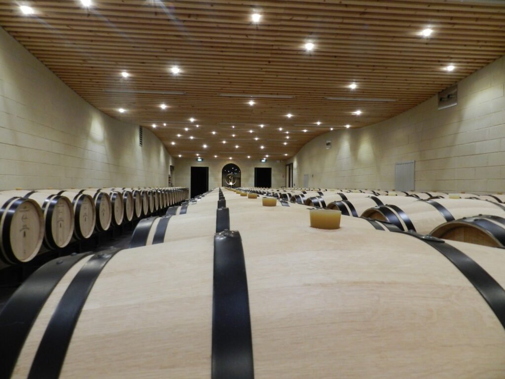 Chai à barriques moderne d’un domaine de Saint-Émilion, cadre d’une visite de cave haut de gamme lors d’un weekend œnologique à Bordeaux.