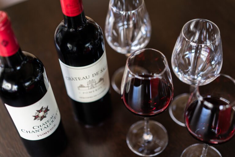 Dégustation de vins rouges de Pomerol avec bouteilles Château de Sales et Château Chantalouette et verres servis.