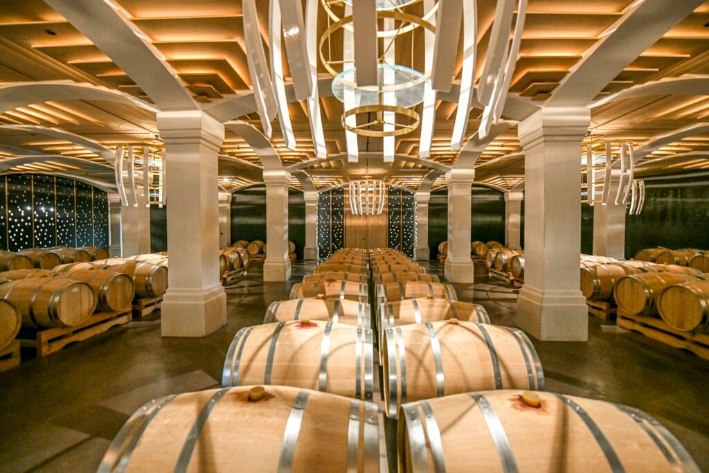 Chai à barriques d’un château viticole Grand Cru à Bordeaux, illustrant l’excellence et l’immersion œnologique