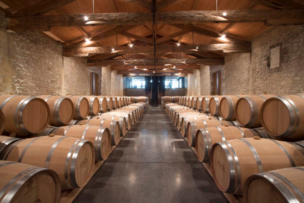 Cave d’un château Grand Cru Classé à Saint-Émilion, révélant l’élevage en barriques lors d’un séjour œnologique haut de gamme.