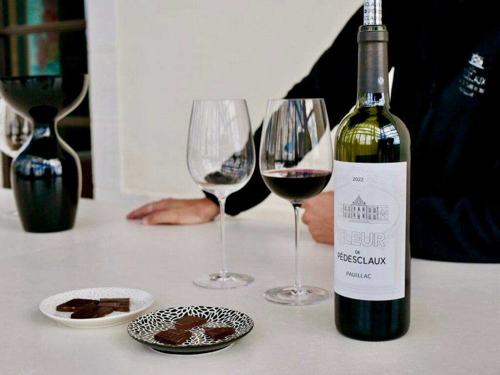 Verres de vin rouge, chocolat et bouteille de cru classé du Médoc lors d’un atelier dégustation vin et chocolat pendant un weekend œnologique à Bordeaux.