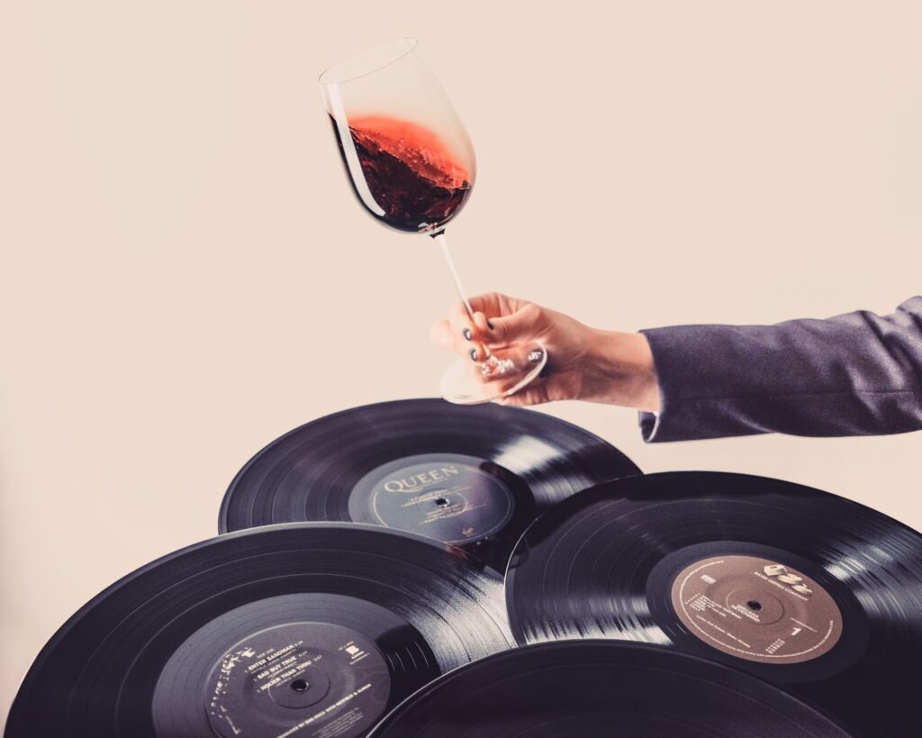 Verre de vin rouge tenu lors d’une expérience sensorielle élégante dans le vignoble de Bordeaux.