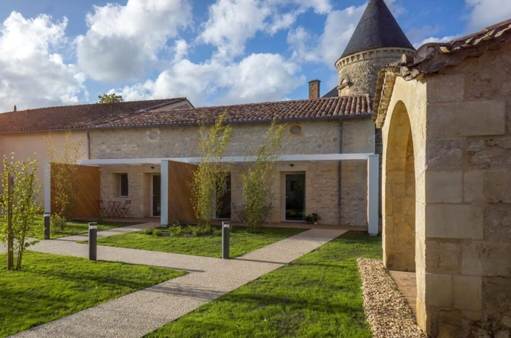 Cour intérieure d’un domaine viticole en pierre à Saint-Émilion, cadre paisible idéal pour une excursion œnologique à Bordeaux