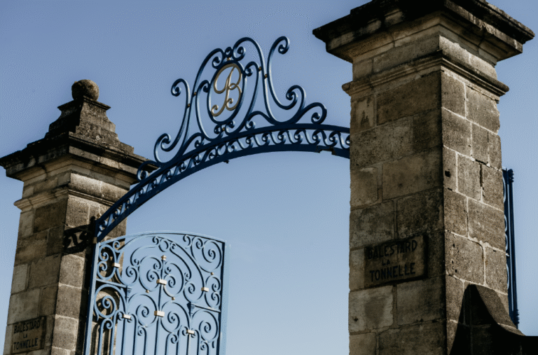 Détail du portail en pierre d’un château viticole bordelais, invitant à l’inspiration et à la découverte du vignoble de Bordeaux