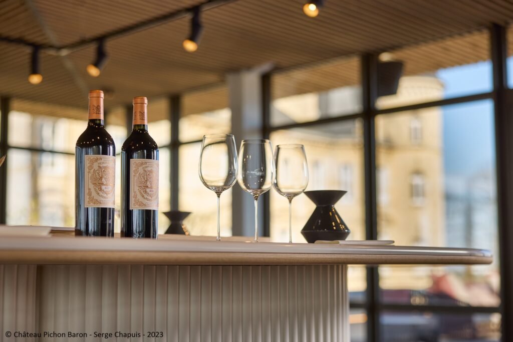 Table de dégustation avec verres et bouteilles de vin dans un salon lumineux, lors d’une expérience œnologique à Bordeaux.