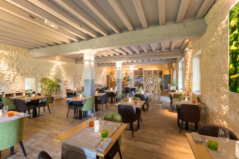 Salle de restaurant élégante en pierre et bois, idéale pour un dîner raffiné lors d’un weekend œnologique à Bordeaux