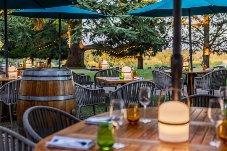 Terrasse extérieure chaleureuse au cœur d’un domaine bordelais, idéale pour un dîner ou une dégustation de vin lors d’un weekend œnologique à Bordeaux