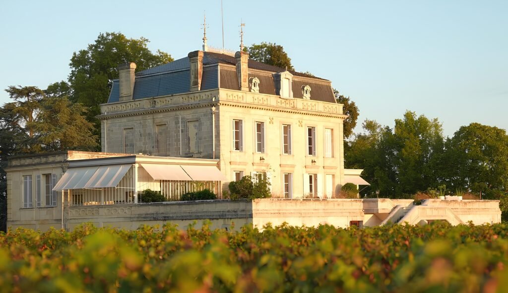 Château bordelais au coucher du soleil entouré de vignes, demeure élégante au cœur d’un vignoble de Bordeaux